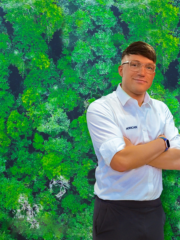 Mylo Kaye in front of a green woodland backdrop